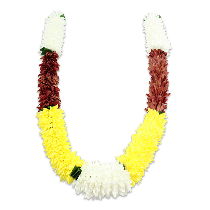 A ceremonial floral garland, formed in a graceful U-shape and set against a crisp white plane, displays traditional colour-blocked sections with meticulous symmetry and quiet dignity. Each arm opens with a short, plush band of clean white blooms-tiny, chrysanthemum-like fabric petals arranged densely to appear soft and voluminous-then slides into a compact swath of deep maroon that lends gravity and contrast. The dominant middle and lower curve is a long, radiant band of bright yellow flowers, their packed, pom-pom texture evoking marigolds and bringing a festive, sunlit energy to the piece. At the bottom centre the two yellow curves meet in a large, lush cluster of white flowers that acts as the visual anchor; along the joins, small dark green leaf-shaped accents punctuate transitions, creating natural separations between colour zones. The lighting in the photo highlights the garland's three-dimensionality and the subtle shadowing between rows of petals, while close-up craftsmanship is evident in the thousands of individual fabric petals and careful assembly-signs of a floral artisan's steady hand. Culturally, the white, yellow and maroon combination reads as purity, prosperity and devotion, making this mala suitable for Hindu puja rituals, temple offerings, wedding ceremonies, or festival decoration during Diwali or Holi. For residents of South Woodford and visitors to George Lane's shops or the nearby parks, this durable, well-made garland offers both ceremonial weight and a reassuringly tactile presence.