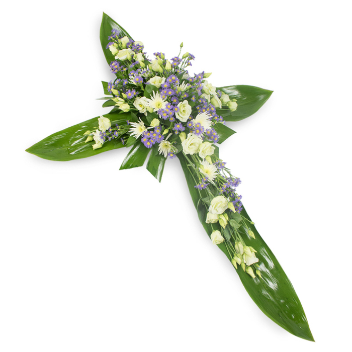 A reverent floral cross shown against a stark white field, photographed from a gentle overhead angle so the geometry of the piece is immediately clear and the craftsmanship is easily read. The cross is built on a foundation of large, glossy tropical leaves whose smooth, deep-green surfaces and prominent veins form a strong, verdant scaffold for the flowers above. At the meeting point of the arms and along each axis lies the floral heart: creamy-white lisianthus with their soft, layered petals and hinting buds, clustered closely with small rounded white chrysanthemums or similar spray blooms that add luminous highlights and tactile variation. Scattered through these are delicate sprays of pale lavender aster or limonium-tiny star-shaped florets that bring a soft violet halo and a sense of gentle movement. Fine green filler foliage is woven throughout, creating subtle texture and breathing room among the main blooms. The composition is bathed in soft light, which accentuates the sheen of the leaves and the tenderness of the petals, and the overall scent is understated-green, slightly sweet, and consoling. Intended as a traditional sympathy tribute, this cross offers a calm, dignified presence at funerals or memorials in South Woodford and the surrounding neighbourhoods, suited to display in church naves, funeral chapels along George Lane, or on a chapel table where visitors gather to remember and reflect with quiet respect.
