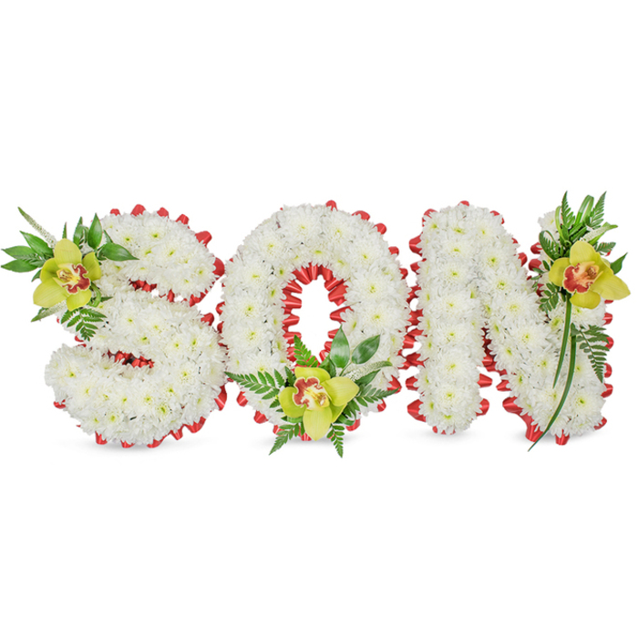 This handcrafted memorial reads plainly and powerfully: the word SON built as three-dimensional letterforms, each face covered in a dense carpet of small white chrysanthemums whose rounded petals diffuse light into a soft, consoling glow. The letters are edged with a continuous band of bright red ribbon, folded into scalloped loops that introduce a rhythmic, almost maritime border against the snow-white florets. At considered points of emphasis-top left of the S, the inner base of the O, and the upper right of the N-sit clusters of yellow-green Cymbidium orchids whose glossy petals and reddish-brown throats give a painterly warmth to the composition. Fine fern sprigs and longer, lance-shaped greenery thread through these groupings, their textures ranging from waxy shine to feathery softness, and they lift the arrangement so it reads as both sculptural and naturally alive. The plain white backdrop keeps attention on the craftsmanship: every chrysanthemum pinned to create a seamless surface, every ribbon loop secured to maintain the scalloped outline, every orchid placed to balance colour and meaning. Intended for funerals, memorial services, or a personalised graveside tribute, this piece balances solemnity with tenderness-white for purity, red for remembrance, green for ongoing life. As a florist working in and around South Woodford-often delivering to families from George Lane to the quieter streets toward Roding Valley Park-I conceive these tributes with steady hands and an understanding of the small comforts flowers can give.