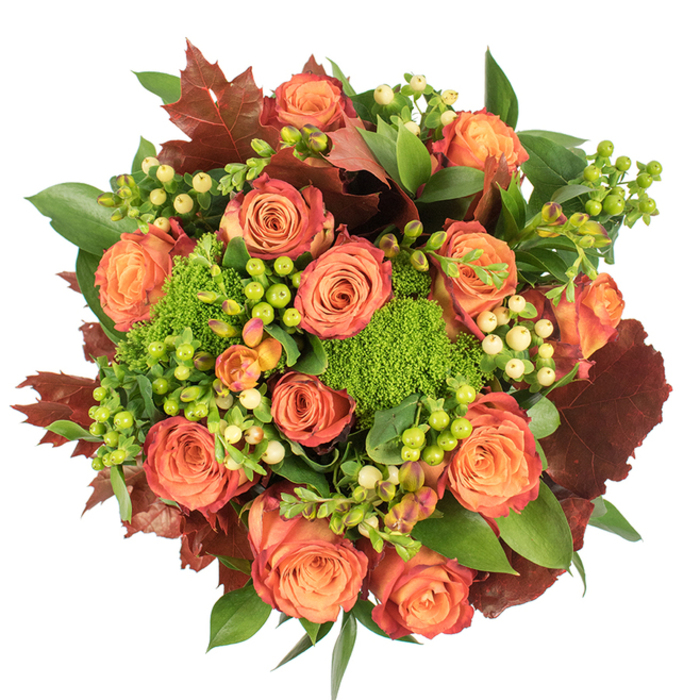 Viewed directly from above on a clean white surface, this composition reads as a luxurious autumn wreath of flowers. The focal point comprises numerous large, fully opened roses whose petals graduate from a warm, sunlit peach at the centre to a coral-orange and finally to russet-tinged edges, creating a gentle ombré that mirrors fall foliage. Interspersed are tight clusters of waxy Hypericum berries-some bright lime, some creamy pale yellow-that introduce small, reflective highlights and a playful, almost jewel-like rhythm. The Green Trick dianthus appears as plush, almost-bristly green cushions, offering an intriguing, velvety texture that counterbalances the rose's softness and deepens the arrangement's visual interest. Rich, lobed leaves in deep red-brown are tucked through the bouquet like autumn confetti, their matte intensity reinforcing the seasonal story, while assorted glossy greens provide a fresh, living backdrop. Light is soft and diffuse, accentuating the roses' velvety surfaces and the berries' subtle gloss without harsh shadows, giving the whole piece a refined, painterly glow. This arrangement feels curated for a distinctly elegant autumn table-perfect for Thanksgiving, an intimate celebration, or as a sophisticated seasonal gift-bringing the colours of Wanstead Flats and nearby parks indoors with the same warmth and depth.