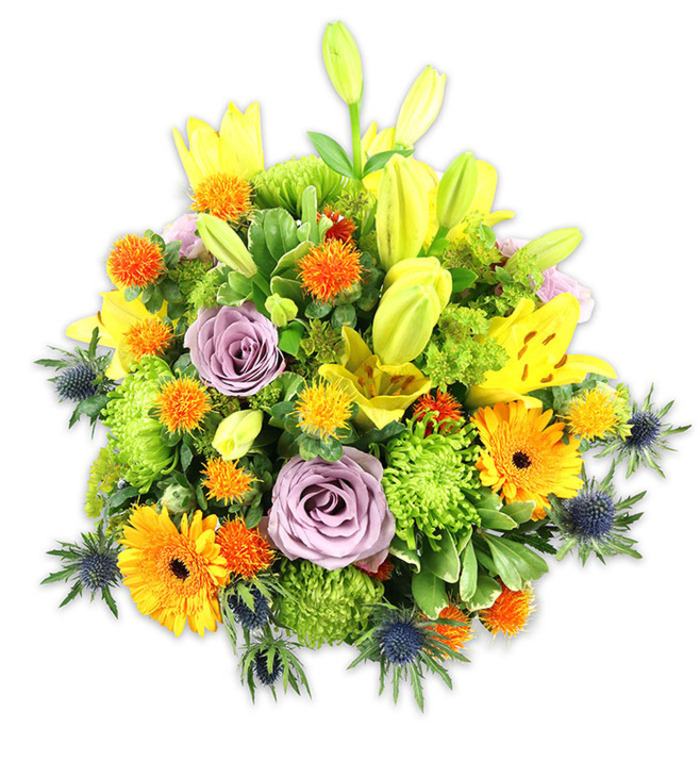 Presented against a stark white background so every hue stands out, this abundant bouquet feels both exuberant and precisely composed. Prominent yellow Asiatic lilies create the vertical architecture: some flowers are fully unfurled with their characteristic freckled petals and exposed stamens, while others remain elegantly furled, stretching skyward as elongated buds. Soft lavender-purple roses are tucked into the heart of the arrangement, offering a cool, romantic counterbalance to the warmer tones and releasing a subtle, floral sweetness. Large orange Gerbera daisies fan their flat petals outward like small suns, and bright lime-green button chrysanthemums fill the body of the arrangement with a ruffled, almost mossy texture that amplifies the piece's lushness. Scattered throughout are small, globe-shaped orange and golden-yellow accent blooms that provide lively, bead-like pops of color, while several blue-grey sea thistles (Eryngium) with spiky, star-like bracts edge the lower and lateral planes, introducing an unexpected, rustic-modern contrast. The foliage varies from broad, glossy lily leaves to delicate filler stems, creating pockets of shadow and depth that let each bloom read clearly. I picture this composition displayed on a dining table in a South Woodford flat near the Roding, or sent as a bright, thoughtful gift from a neighbour on George Lane; its mood suits birthday celebrations, warm thank-you gestures, or a comforting, colourful sympathy tribute. The overall impression is one of handcrafted abundance - textured, fragrant, and balanced - where bright yellows and oranges glow against calming lavenders and cool blue-greys for an arrangement that both celebrates and soothes.
