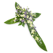 A solemn, elegant floral cross captured from a soft overhead angle against a clean white background, its quiet simplicity emphasised by even, diffused light. The base of the cross is crafted from large, glossy tropical leaves-think Ti leaves-laid edge to edge so their deep green, waxy surfaces and visible veins form the defined arms and centre of the Christian cross. At the heart and tracing each arm sits a generous, carefully layered cluster of pale flowers: ruffled creamy-white lisianthus with their multi-layered petals and tender buds, interspersed with small, pure white daisy-like chrysanthemums or spray blooms that catch the eye with tiny bright centres. Delicate sprays of lavender-hued, star-shaped aster or limonium weave through the white blooms, offering a soft violet whisper that adds depth and a contemplative note to the palette. Finer green fillers are tucked between blooms, adding air and movement and softening the transition between lush greens and pale petals. The overall scent is faintly green and floral-subtle rather than heady-suggesting early morning dew on leaves. This composition reads as a respectful sympathy tribute, chosen for funerals, memorial services, or church displays where the cross shape and tranquil colour scheme convey consolation and hope. As a South Woodford florist might arrange for delivery to George Lane chapels or to a service near South Woodford station, the design balances structure and tenderness: the pronounced, verdant foundation gives solidity while the creamy whites and lavender accents offer gentle solace and a sense of peaceful remembrance.